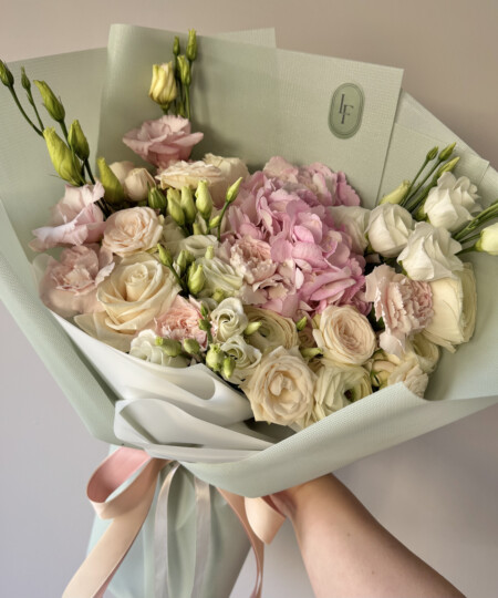 Romantyczny bukiet z różami, różową hortensją i eustomą w pastelowej kolorystyce, elegancko ułożony w delikatnym stylu przez Lu La Fleur.